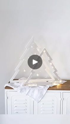 a white cabinet with a triangle shaped object on it's top and lights in the middle