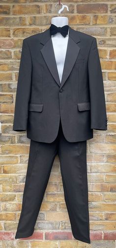 "KINGLOUIEVINTAGE   Quality Vintage & British made clothing DESCRIPTION = Vintage 1980's Quality black tuxedo dinner suit. Collared neck with notched lapels and single button front opening. Buttoned cuffs, two side flap pockets and single breast pocket. Double rear vent and fully lined inside. Trousers have zip/clasp fly and two side open pockets. Buttons inside for braces, two rear buttoned pockets. Quality retro evening wear. Accessories not included.  BRAND = Varteks SIZE (UK) = 40 CONDITION Classic Black Party Suits, Dinner Suit, Tuxedo Wedding, Black Tuxedo, Made Clothing, Suit And Tie, Sport Coat, Braces, Evening Wear