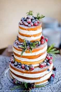 a three tiered cake with berries and icing