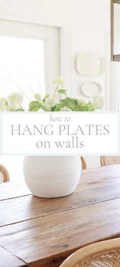 a wooden table topped with a white bowl filled with flowers