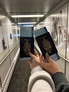 two people holding up their passports in front of them