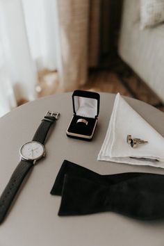 a watch, tie and cufflinks sitting on a table