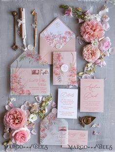 the wedding stationery is laid out with pink flowers and other things to put on it