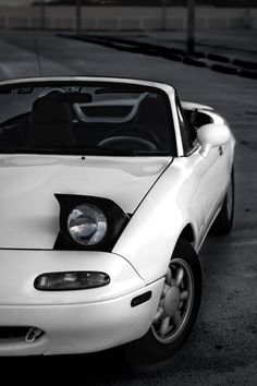 a white sports car parked in a parking lot