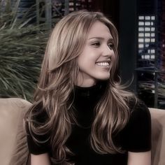 a woman with long hair sitting on a couch