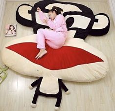 a woman in pink is sitting on a bean bag chair with her legs spread out