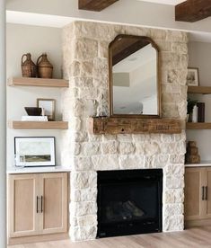 a living room with a fire place and wooden shelves on the wall, along with a large mirror above it