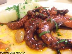 an octopus is covered in sauce and garnished with parsley on the side