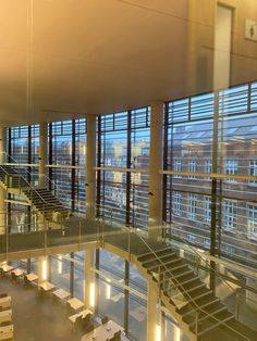 the inside of a large building with glass walls and stairs leading up to it's second floor