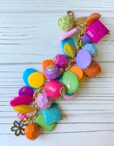 a multicolored bracelet with lots of beads and charms hanging from it's chain