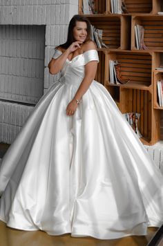 a woman in a white wedding dress posing for the camera