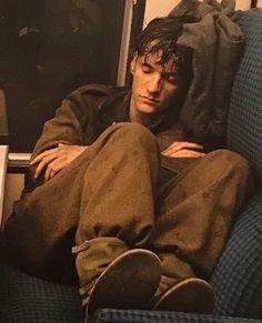 a man sitting on top of a blue couch