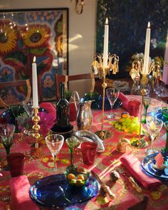 the table is set with wine glasses, candles and other decorative items in front of it