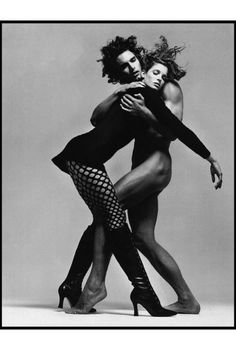 two people are dancing with each other in black and white, one is holding the other's back