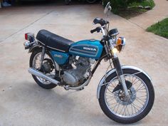 a blue motorcycle parked on top of a driveway