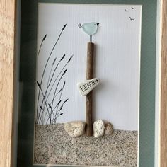 there is a rock with a bird on it and some seaweed in the sand