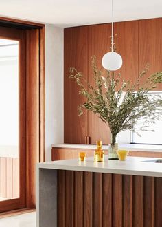 a kitchen with wooden cabinets and white counter tops next to an open door that leads to the outside