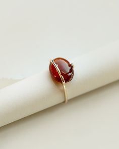 A limited edition garnet ring with a natural ethically sourced cinnamon red hessonite garnet set in yellow gold. The oval garnet cabochon is set in a unique band and prong setting to better showcase the beauty of the stone. Each ring is completely handmade in our studio using traditional goldsmithing techniques exclusively. Available in 9k & 18k solid yellow gold. Hessonite garnet: app. 14mm, app. 7cts, light blue, ethically sourced, origin: Central African Republic Band Width: 1.3mm, recycled g Garnet Ring For Men, Oval Cabochon Ring, Modern Garnet Ring, Oval Stone Ring Design, Gernet Ring, Statement Garnet Ring, Oval Stone Rings, Hessonite Ring, Stone Ring Design