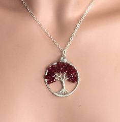 This beautiful Small size (Compare to my standard size) Red Garnet Tree of Life Pendant is hand wire wrapped with gorgeous Garnet gemstone using .925 Sterling Silver wires for the tree trunk and branches.  It is a beautiful gift to give or receive! January Birthstone, the symbol of Love ~~The pendant measures between 1.30  to 1.35 inch in diameter. The US quarter coin is about 1 inch(25mm) in diameter.  ~~The pendant  comes on an .925 Sterling Silver cable chain & finished with a .925 sterling silver lobster clasp.  ~~  Each pendant is handmade, so please allow slight variations from the shape of the branches and placement of the stones as shown ~~About GARNET gemstone:  The Garnet is a stone of purity and truth as well as a symbol of love and compassion. The Tree of Life is a universal sy Red Hand Wrapped Necklace As Gift, Silver Plated Wire Necklaces With Gemstone For Gift, Red Hand Wrapped Necklace For Gift, Sterling Silver Wire Wrapped Crystal Necklace, Gift Silver Plated Gemstone Necklace, Sterling Silver Wire Wrapped Crystal Necklace With Round Pendant, Gift Silver Plated Wire Necklace With Gemstone, Hand Wrapped Red Necklace As Gift, Gift Necklace With Gemstone On Silver Plated Wire