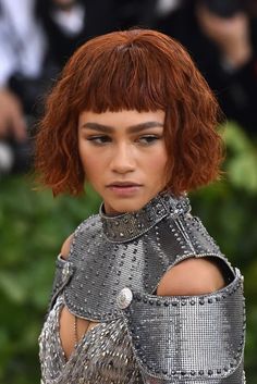 a woman with red hair and silver dress