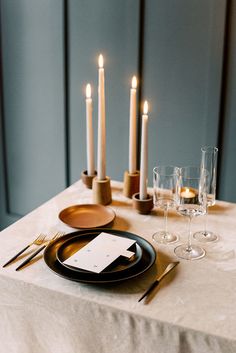 a dinner table with candles and place settings