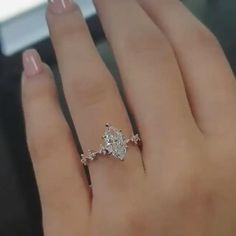 a woman's hand with a diamond ring on top of her finger and an engagement band