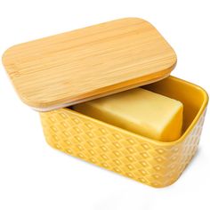 a yellow container with two pieces of cheese in it and a bamboo lid on top