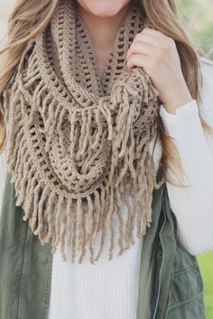 a woman wearing a scarf with fringes on it