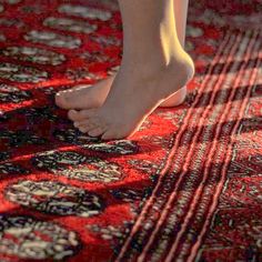 a person standing on top of a red rug