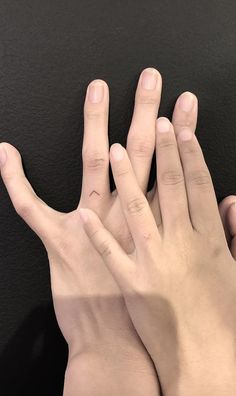 two hands are touching each other with their fingers