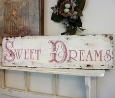 a sign that says sweet dreams hanging on a wall next to some pictures and wreaths