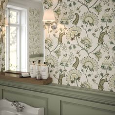 a bathroom sink sitting under a mirror in front of a wall mounted faucet