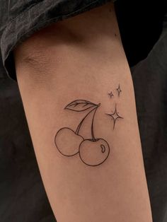 a small cherry tattoo on the right side of the leg, with stars in the background