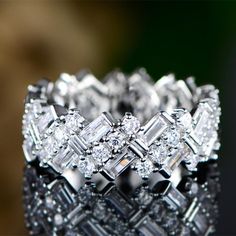 a close up view of a wedding ring with diamonds on it's sides and in the middle