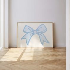 an empty room with a painting on the wall and wood flooring in front of it