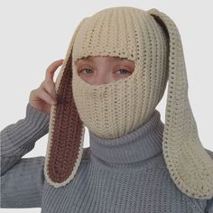 a woman wearing a knitted bunny mask