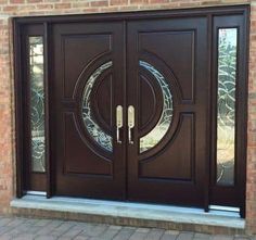 a brown double door with two sidelights and glass panels on the front of a brick building