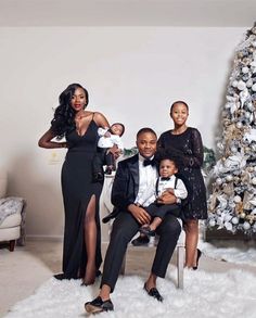 a family posing in front of a christmas tree