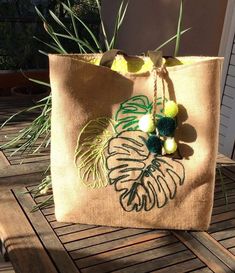 a bag sitting on top of a wooden table next to a potted palm tree