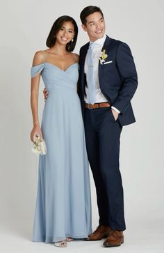 a man and woman in formal wear standing next to each other smiling at the camera