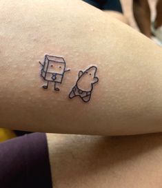 a person with a small tattoo on their arm that has an image of a dog and a cat