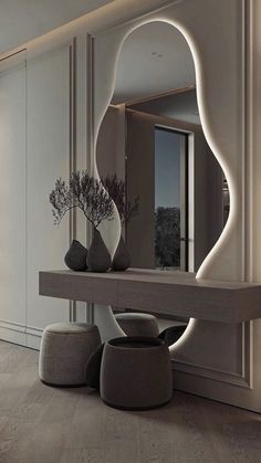 a large mirror sitting on top of a wooden table next to a vase filled with flowers