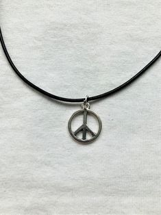 Peace Symbol pendent with a leather cord style necklace. The necklace is 12 and a half inches long but has a 2 inch extender at the end so you can adjust the size. Any questions don't hesitate to drop me a message. Adjustable Symbolic Charm Necklaces For Everyday, Hippie Choker With Adjustable Cord As Gift, Hippie Choker With Adjustable Cord For Gift, Hippie Style Choker With Adjustable Cord As Gift, Hippie Style Adjustable Nickel-free Necklaces, Adjustable Black Spiritual Charm Necklaces, Black Adjustable Spiritual Charm Necklace, Adjustable Spiritual Jewelry With Peace Sign, Necklace Pendent