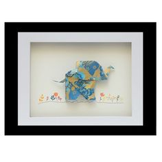 an origami elephant in a white frame