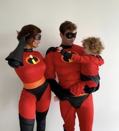 a man and woman dressed as the incredibles with a child on their back, standing next to each other