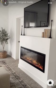 a living room with a fireplace and tv mounted on the wall