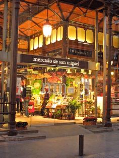 a store front with people standing outside at night