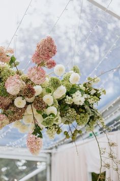 the flowers are hanging from the ceiling in the wedding ceremony room at the venue,