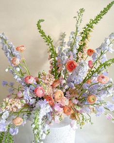 a white vase filled with lots of different colored flowers