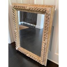 a large mirror sitting on top of a hard wood floor